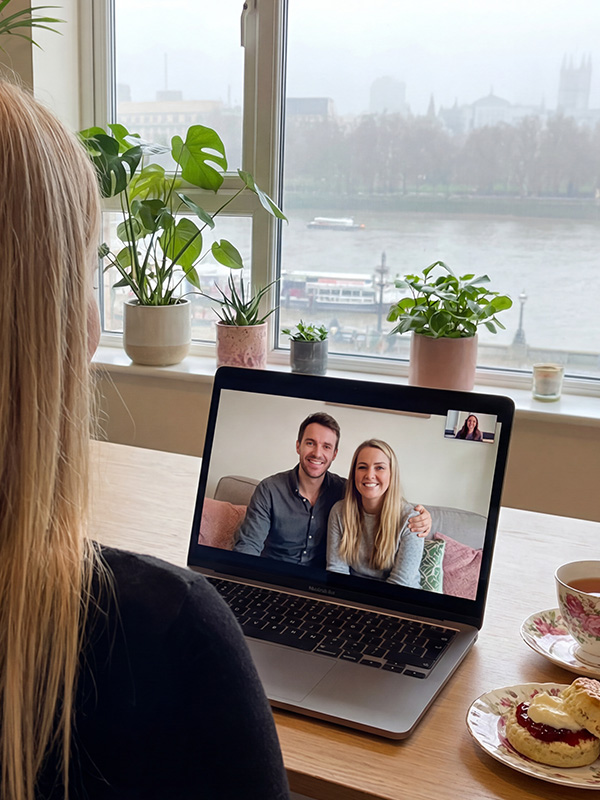 a zoom meeting with a couple over the shoulde blonde laptop
